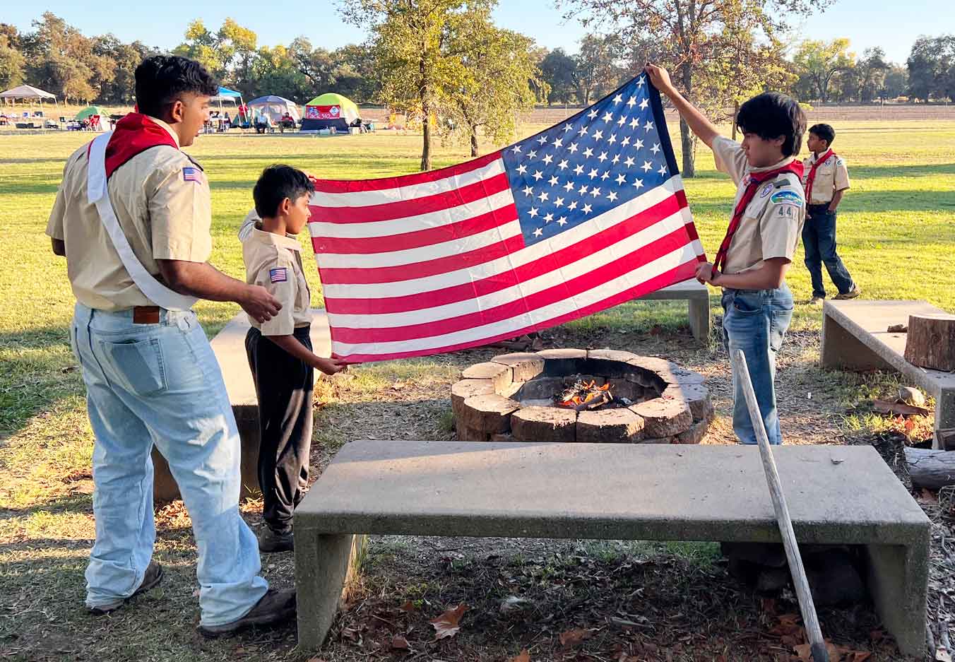 Scouts present a flag prior to retiring it over a campfire